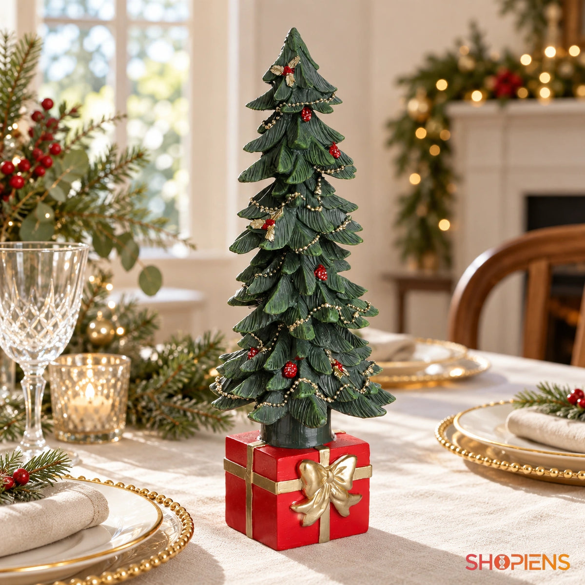 Brad ornamental verde cu bază cadou roșie, 33 cm pe masa festivă, în lumină naturală | Shopiens®