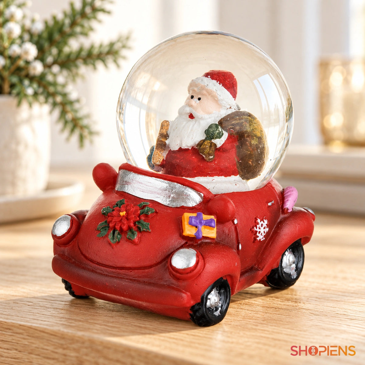 Mașinuță roșie cu glob și Moș Crăciun pe o consolă într-un decor luminos | Shopiens®