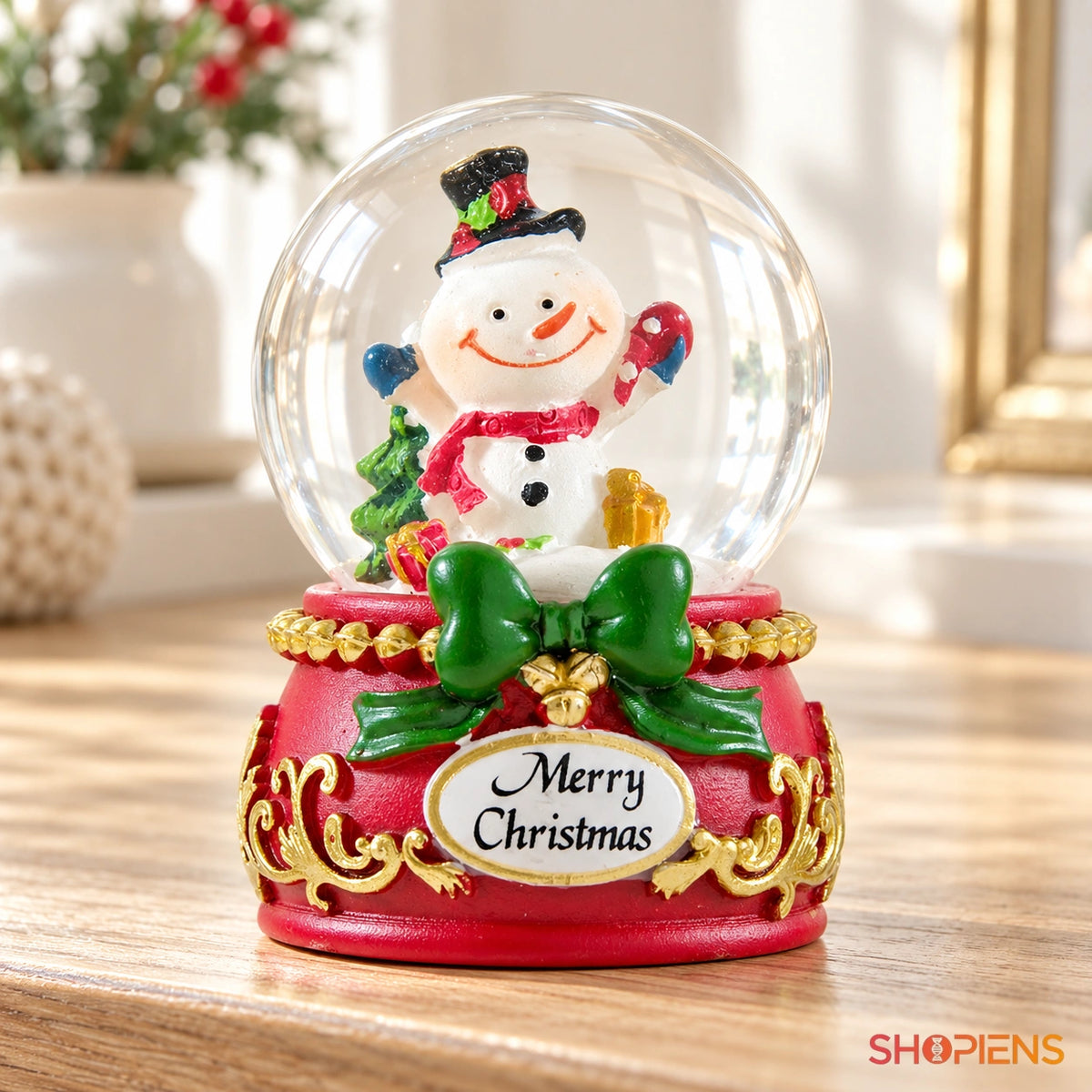 Glob de zăpadă cu om de zăpadă și fundă, 6 cm pe o consolă într-un decor luminos | Shopiens®