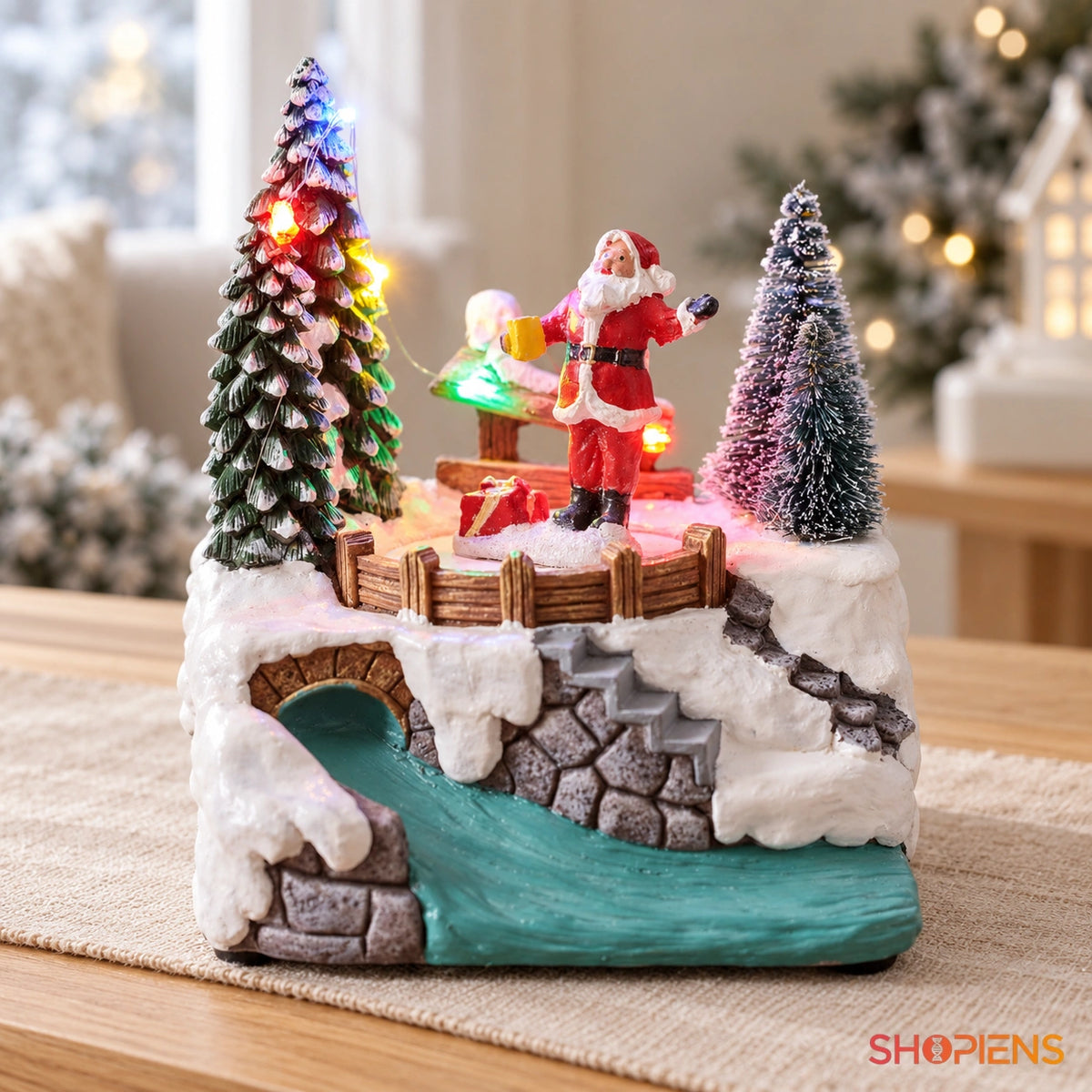 Scenă cu Moș Crăciun rotativ, râu și lumini, 15 cm pe o consolă, într-un decor festiv în lumină naturală | Shopiens®