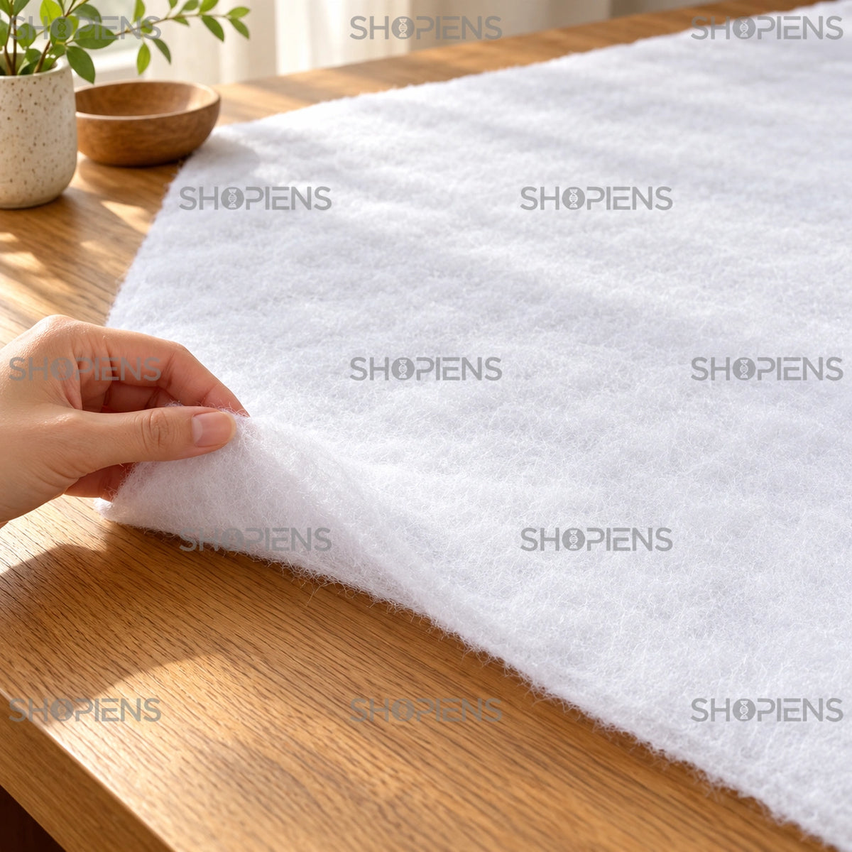 Țesătură albă pentru decor de iarnă, 120 × 80 cm în prim-plan, cu o mână pentru comparația texturii și mărimii | Shopiens®